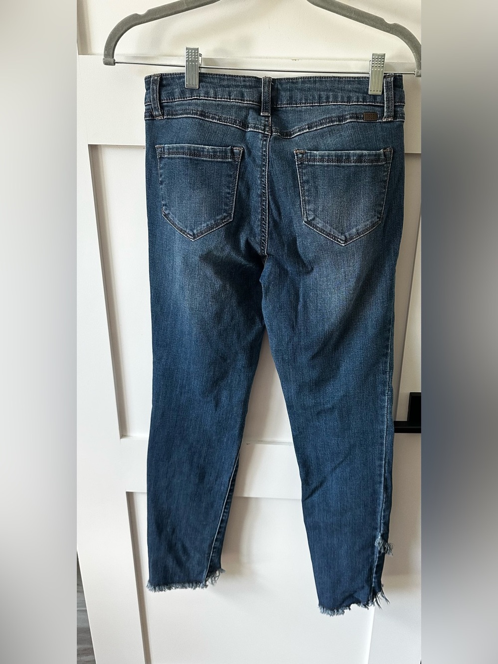 1822 Denim distressed blue jeans with a distinct frayed, V-shaped raw hem 6